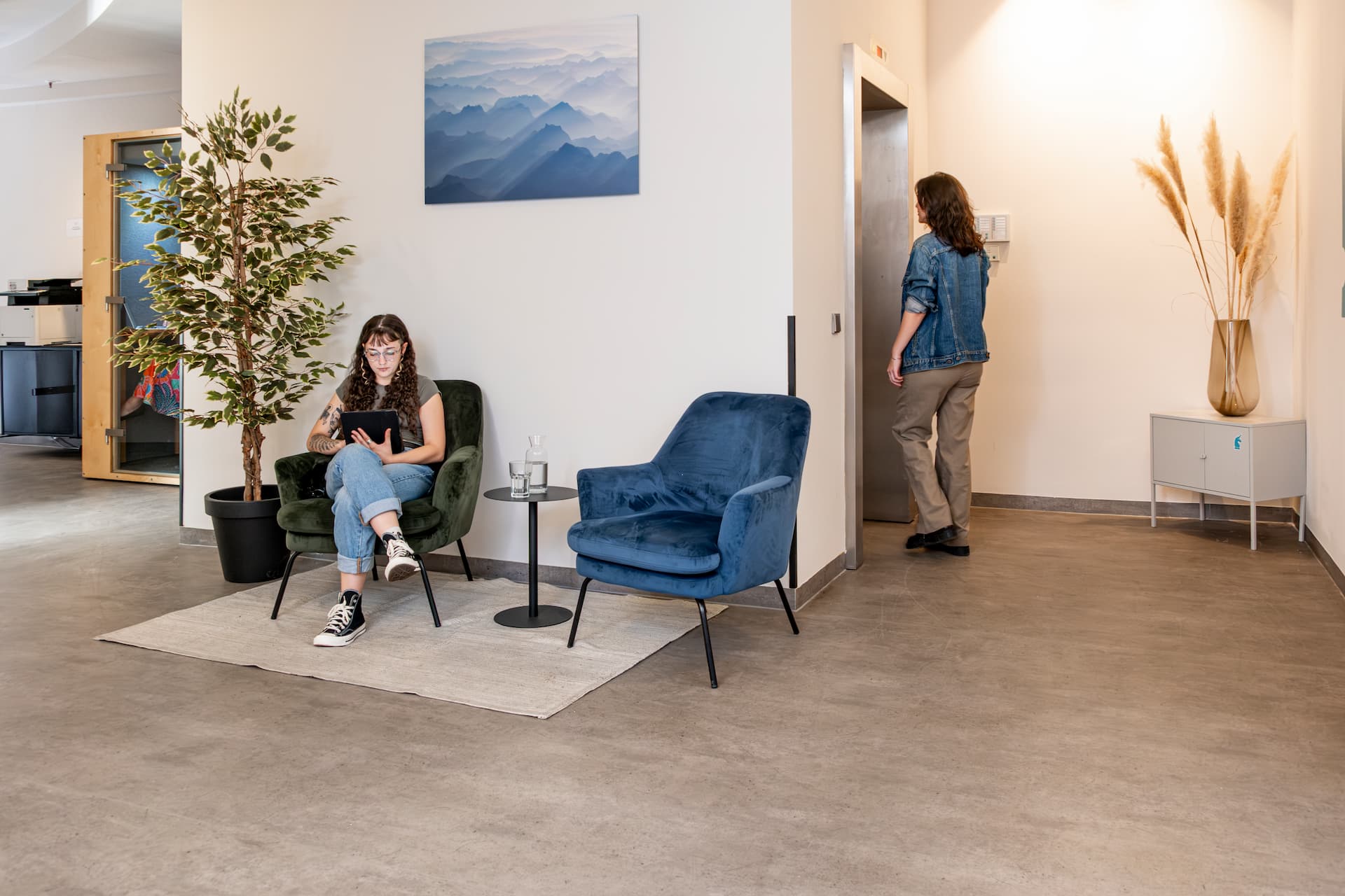 Modern gestalteter Flur mit Loungeecke und Aufzug