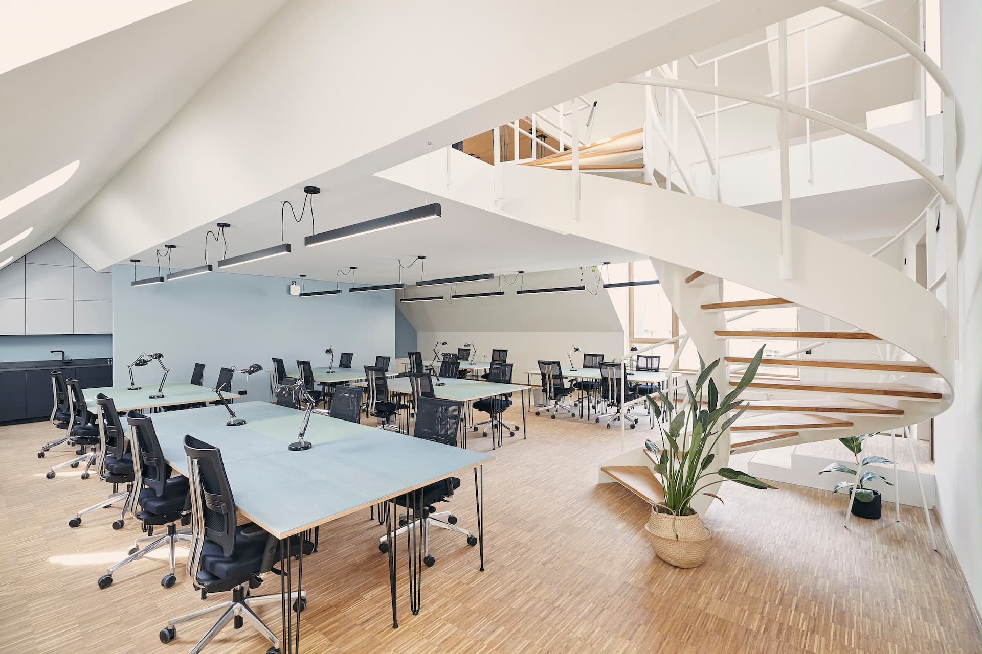 Großes Teambüro mit eleganter Wendeltreppe.